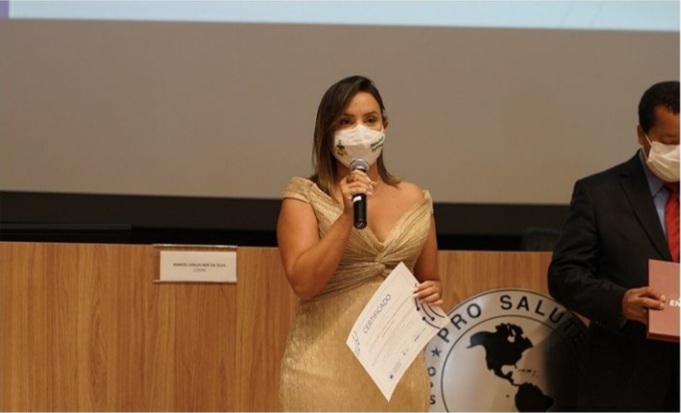 Enfermeira Mara Gabriela recebendo o prêmio de experiência inovadora desenvolvida no âmbito do Sistema Único de Saúde (SUS).