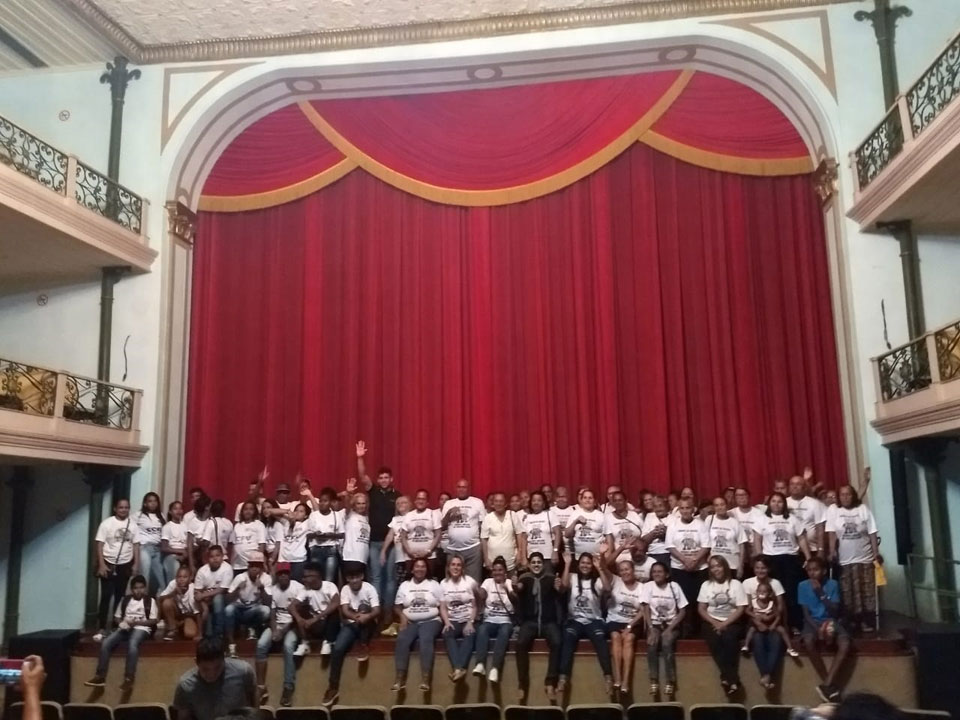 Idosos e adolescentes sobem ao palco do Teatro Deodoro. 